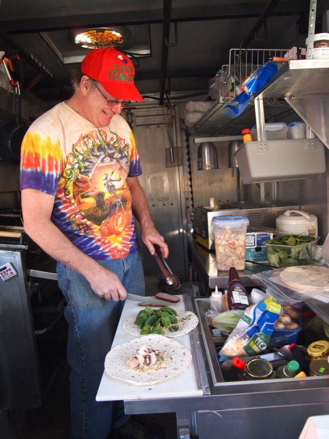 Photo by Ricky Emmons - Photography Editor. Lovin' Tenders food truck owner Craig Hoge prepares food for his new customers.