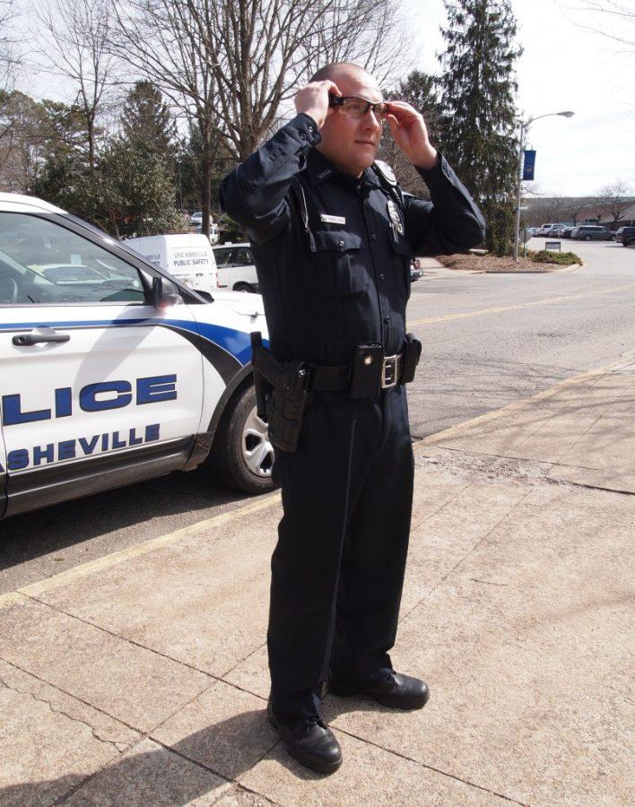 Patrol Officer Craig puts on his new camera, attached to his glasses. The
cameras provide additional ways to monitor students and record crime. Photo by Ricky Emmons.