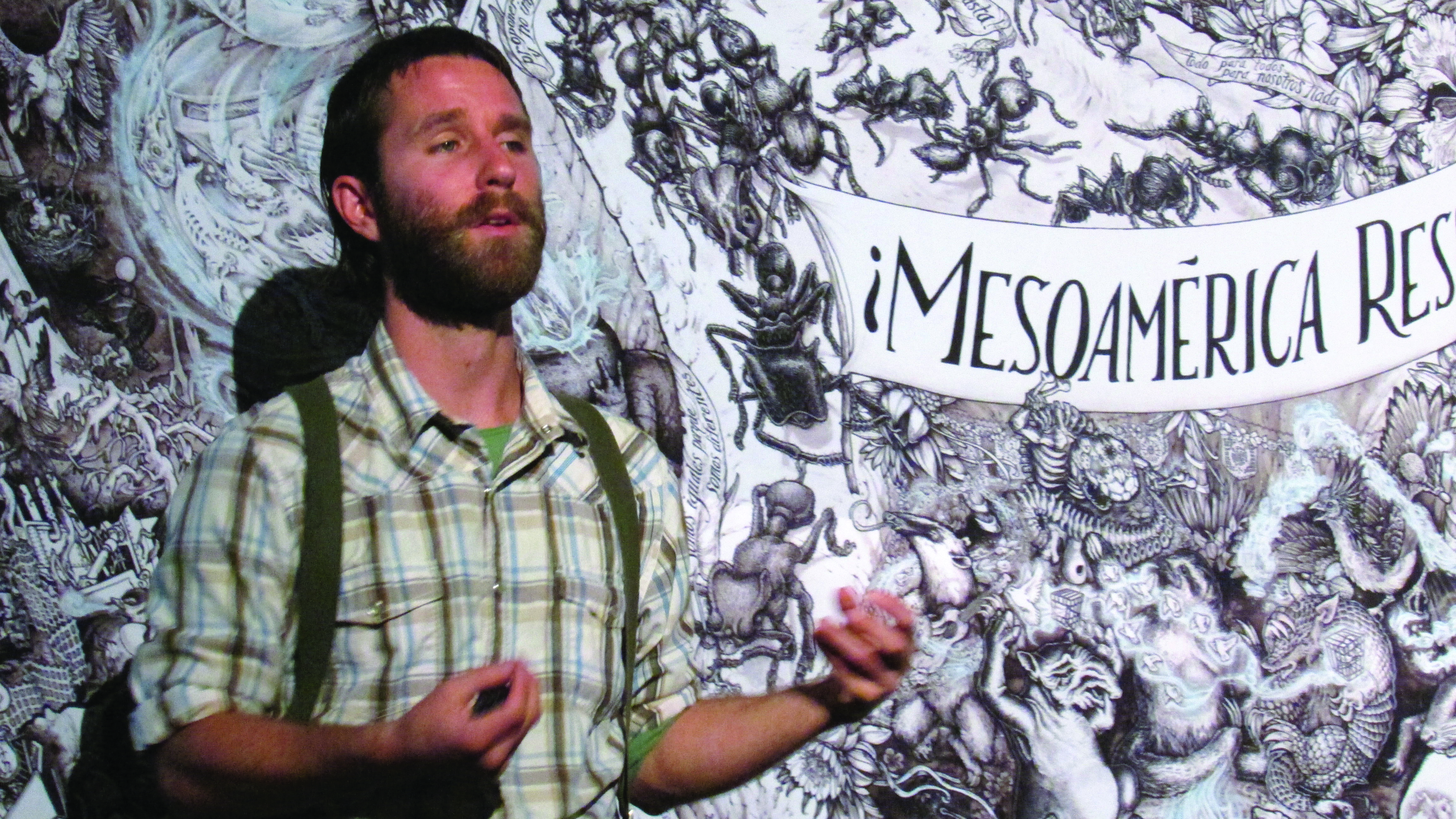 Beehive Collective member Kyle Gibson explains the group's newest poster. Photo by Cory A. Thompson - staff writer