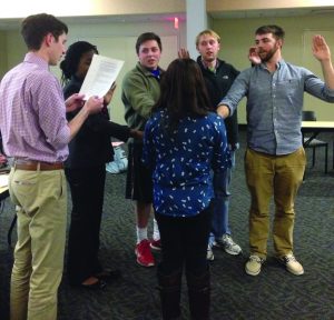 Vice President Josh Owen and Sen. Paolo Salas swear in the four new SGA senators last Wednesday night. Photo by Harper Spires. 