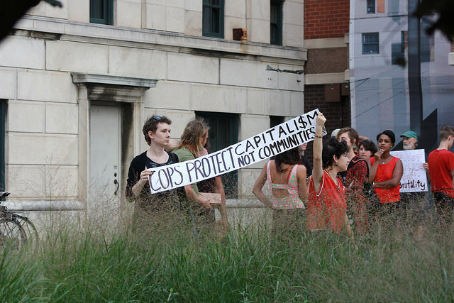Protesters hold signs in honor of victims to police brutality in downtown Asheville on Aug. 24. Photo by Brian Vu - Photography Editor