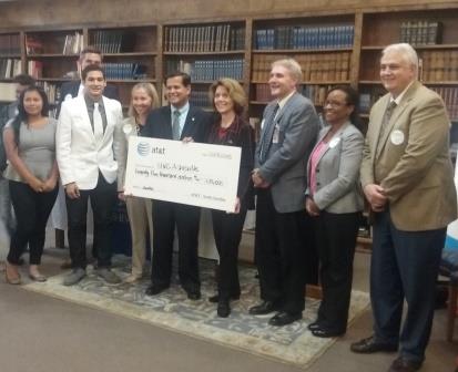 Carlos Sanchez of AT&T presents the $25,000 check to Chancellor Mary Grant. Surrounding them, from left to right: Juntos program students, N.C. Sen. Terry Van Duyn, Tony Baldwin, Pamela Baldwin and Tony Tipton (Photo by Timbi Shepherd, Editor-in-Chief)