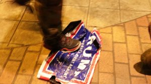 A participant of the Fight for $15protest stomps on a Trump banner that had been resting on the ground outside the Peace Center on Feb. 13, 2016, in Greenville, S.C. (c) Calla Hinton