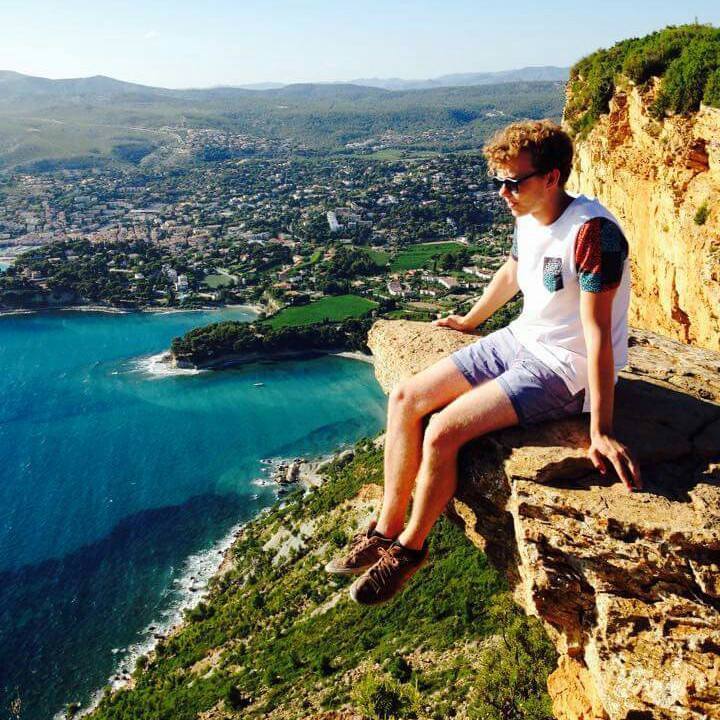 Aymeric Assemat stands on a cliff over the town of Cassis in south of France.