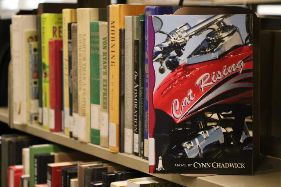 A copy of Cat Rising written by Lecturer Cynthia Chadwick rests on a shelf in D. H. Ramsey Library.
Photo by: Rachel Van Noordt