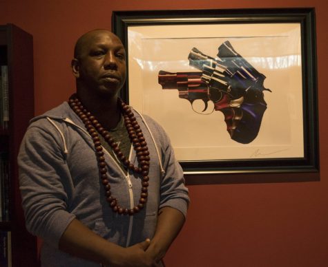 Local Photographer, Micah Mackenzie poses in front of one of his pieces titled, America.
