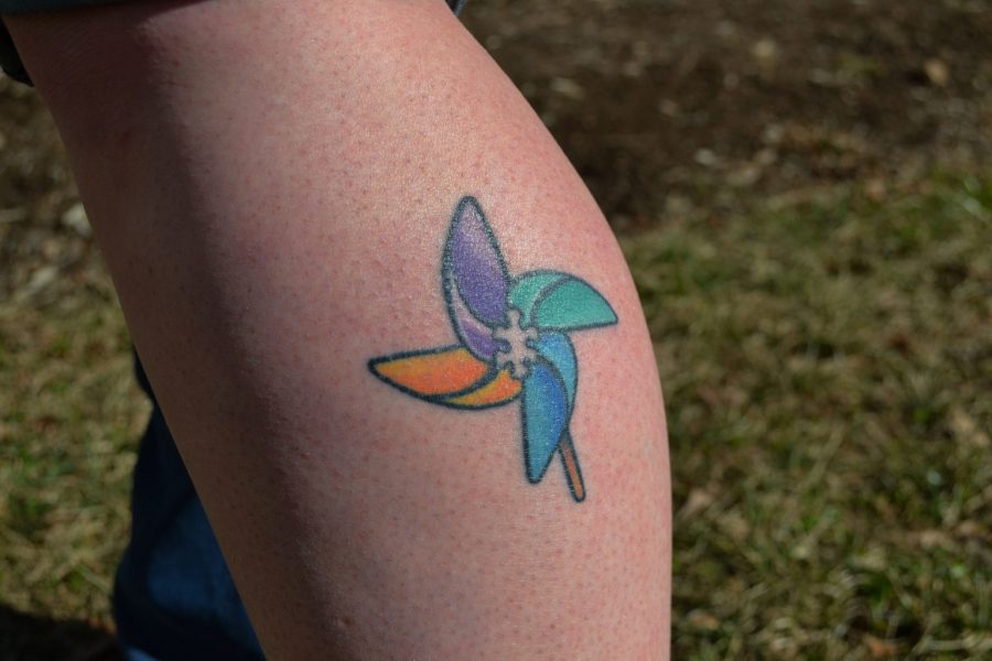 Rae Williams displays her pinwheel tattoo in honor of her brother who is autistic. Photo by Logan Todd. 