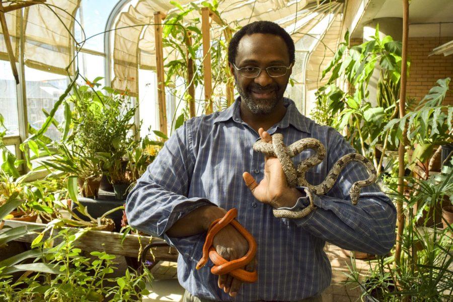 Landon Ward, environmental studies instructor hold two snakes commonly found in the Everglades. Photo by Bryce Alberghini 