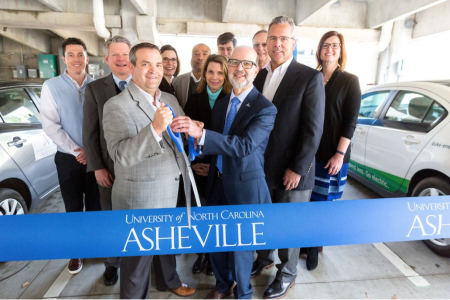 Jason Walls and Joe Urgo cut the ribbon to announce the opening of the new electric vehicle charging
stations in the P12 parking lot on campus. Photo courtesy of UNC Asheville.