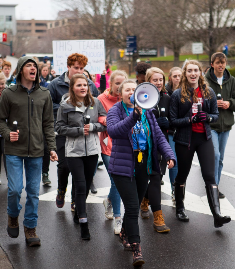 Aryelle Jacobsen leads protesters in chants during a march on College St. March 25. The crowd of thousands makes up March for Our Lives Ashevile, a sister march to the larger movement by the same
name occuring the same day in Washington D.C., as well as in other cities across the country. The march responds to the mass shooting which took place at a high school in Florida Feb. 14. Photo by Nicholas Haseloff.