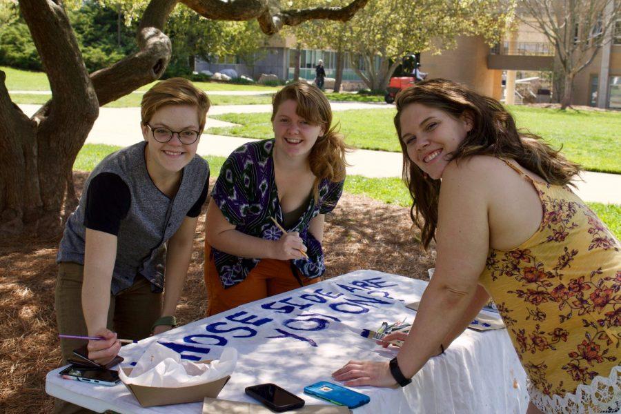 Anna Digman, Natalia Izlar and Erika Covey paint a banner for UNCA Divest, a student organization aiming to divest fossil fuels on all 17 UNC
system campuses. Photo by Annabel Gibson.