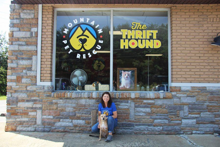 Joelle Warren smiles outside of the Thrift Hound with a current foster, Thomas. Thomas is available for adoption. Photo by Virginia Taylor.