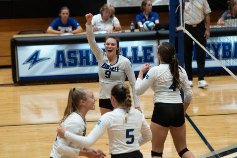 Cara Guthrie, captain of the womens volleyball team, celebrates with teammates after a successful set. Photo by Adrian Etheridge 