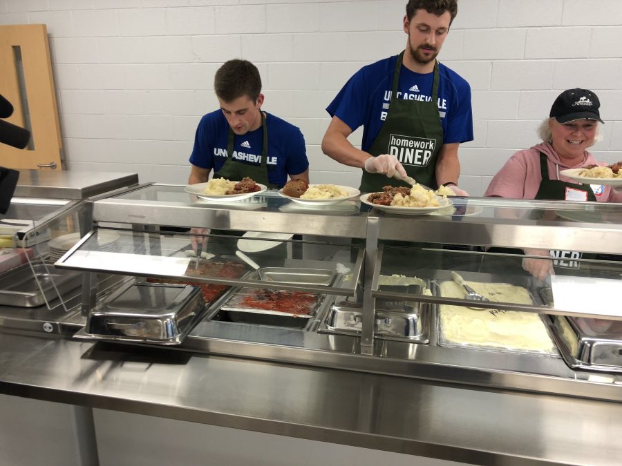 Basketball players and other community members serve dinner for the United Way's Homework Diner held at Asheville Middle School. Photo by UNC Asheville Athletics 