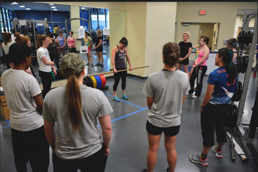 Students gather around an instructor demonstrating how to properly deadlift at Womens Weightlifting Week last year.