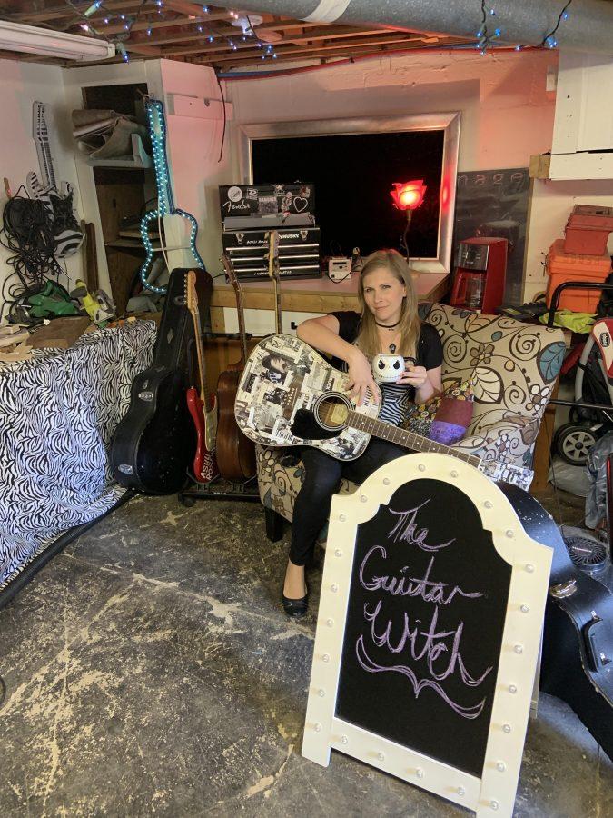 Photo by: Eliza Hill      Ashli Rose Bales, the guitar witch sips tea among her many creations hanging in her home workshop where she tackles larger projects.