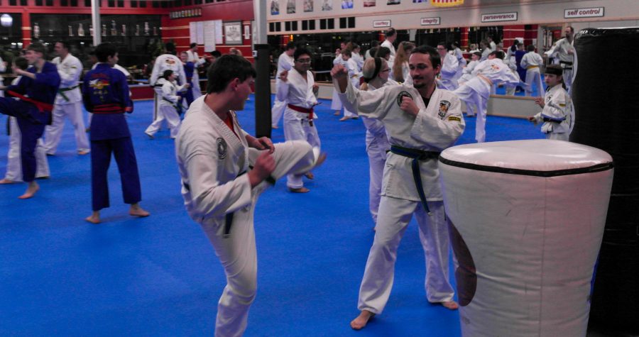 Photo by Ezekiel Ballard
After going through synchronized movements as a class, students are split into two-person teams to practice kicks and movements with each other while instructors move through the room to assist and give guidance.
