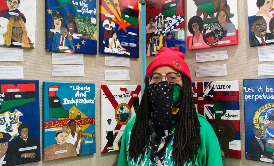 Heather Tolbert, Flowstate artist in residence, poses in front of her Black History Month display at the East Asheville Public Library.