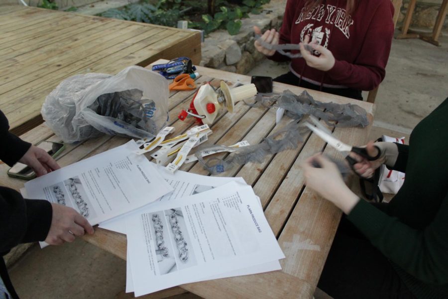 Students working on making the reusable bags inside of the UNCA glasshouse.