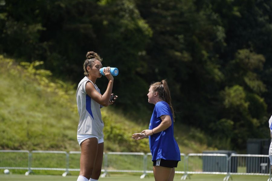 Assistant Coach Bella Iorio gives pointers to Junior Kaiya Boyd during a water break. 