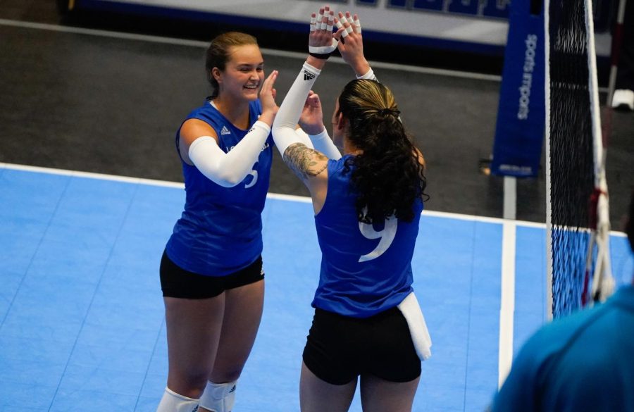 Freshman Lindsey Springer and Senior Lexi Cole share a high-five after winning a point. 
