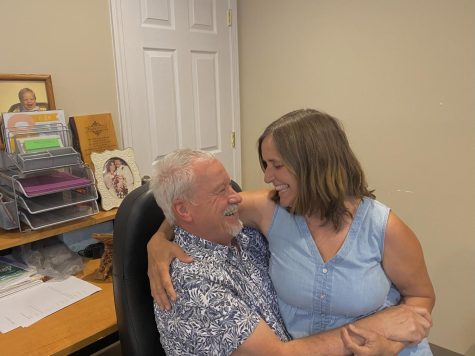 Marriage counselors, Johnny and Robin Hughes, laugh in his office. 