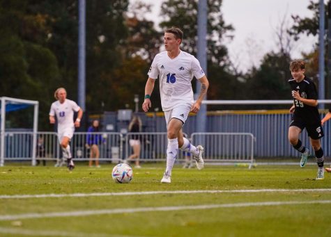 Senior Andrew Rossetti dribbles the ball down the sideline during a match against Winthrop, his first match back after his injury in the 2021 season. 
