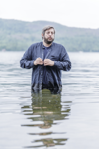 Eugene Mirman standing in a lake. 