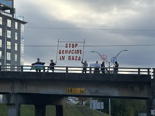 Protesters holding signs on Montford Avenue above Interstate 240.