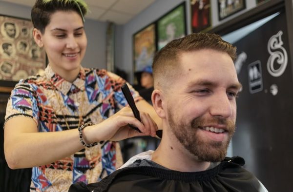 Nur Shawamreh cutting a customer’s hair.