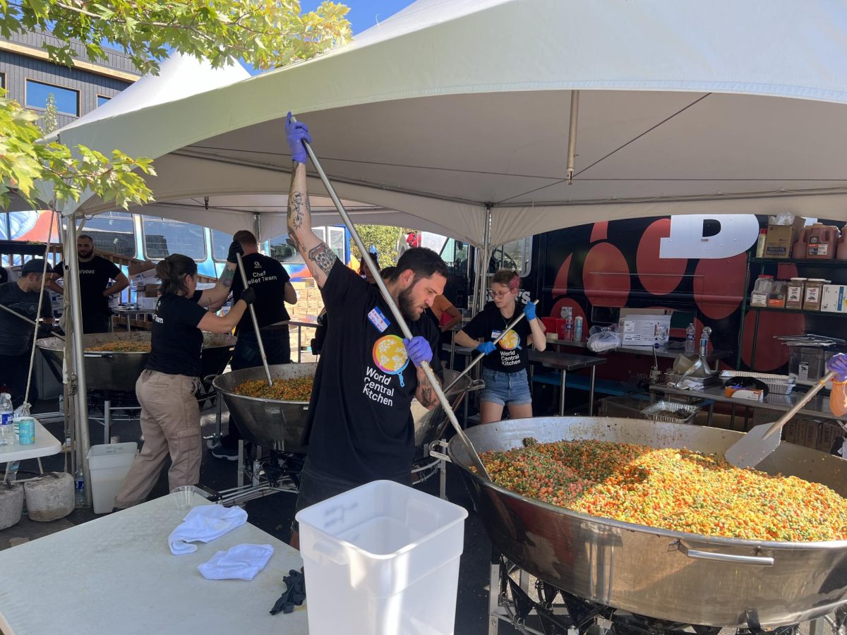 Lindsey Toman stirring food along with World Central Kitchen Staff