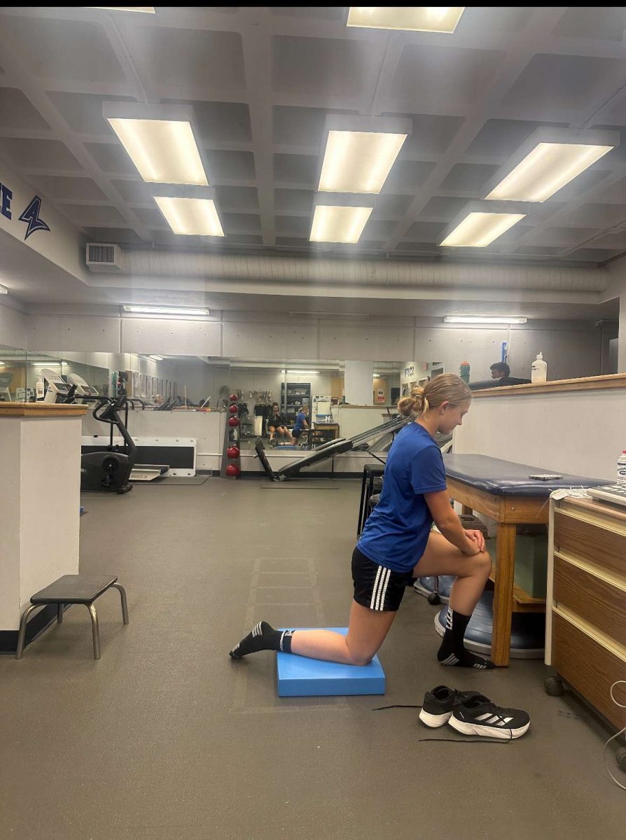 Women's soccer player Jordan Schaetzy stretching in the training room.