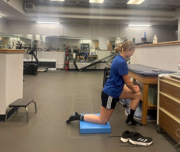 Women's soccer player Jordan Schaetzy stretching in the training room.