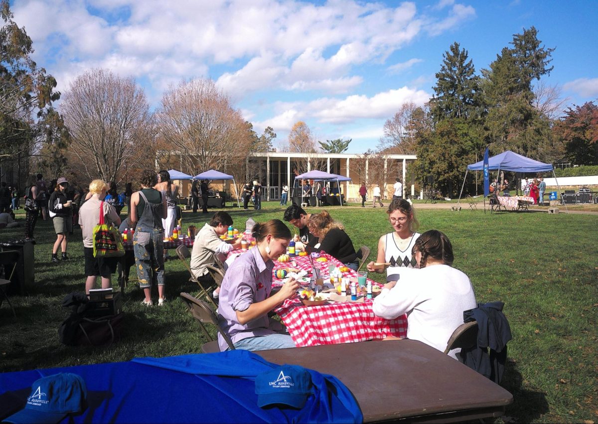 Students paint pumpkins at Turning of the Maples.
