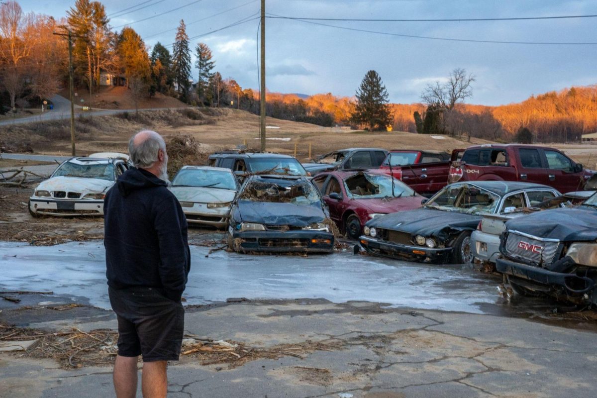 Bob Buchanan observes smashed customer’s cars and debris still piled up next to his shop.