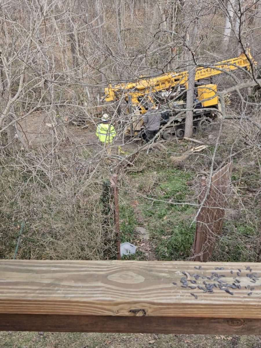 A drill rig less than 15 feet from the porch of Anne Walch, a Five Points resident, furthers destruction of an UNCA-owned urban forest.