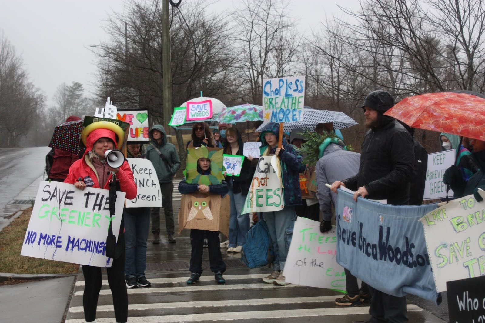 Community members gather along Broadway with signs to gain the attention of the cars passing by.