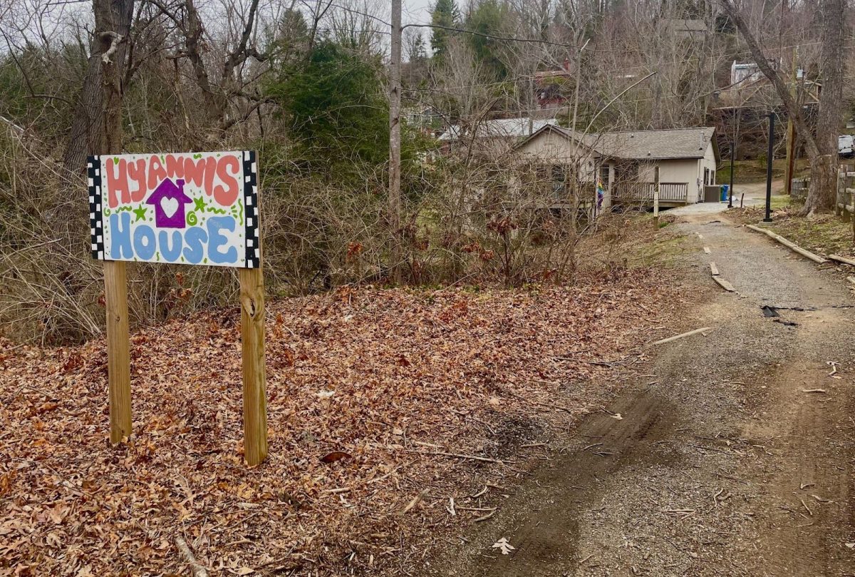 Hyannis House sign made by students on the gravel path leading from the campus to the student space.