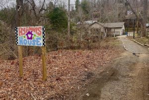 Hyannis House sign made by students on the gravel path leading from the campus to the student space.