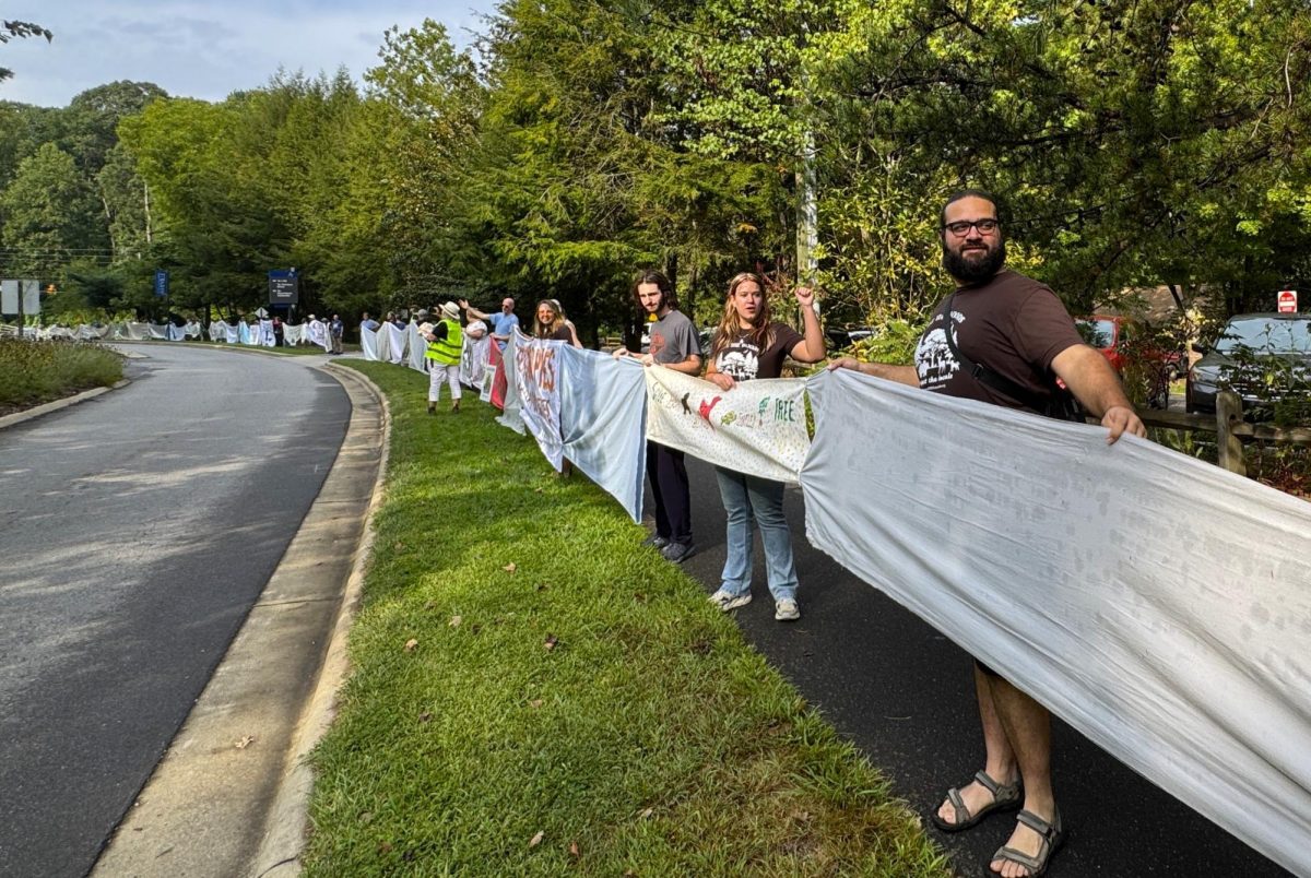 Brooke Pedersen [second from the right] and Luis Reyes [right] hold banners during the Wrap The Woods event.