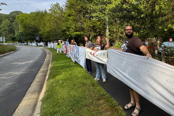 Brooke Pedersen [second from the right] and Luis Reyes [right] hold banners during the Wrap The Woods event.