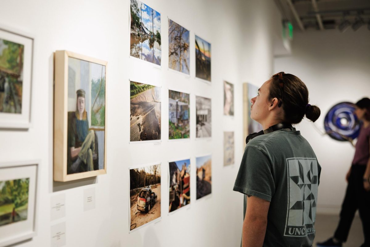 Gallery visitors look at student and faculty artworks. 