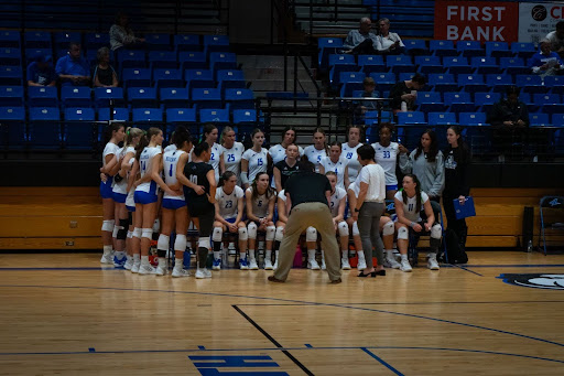 Photo of UNC Asheville Volleyball team in a huddle.