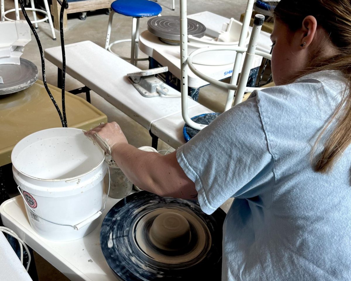 Ren Younce centering and sculpting clay in Owen Hall.