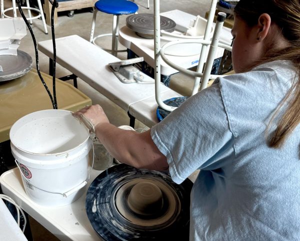 Ren Younce centering and sculpting clay in Owen Hall.