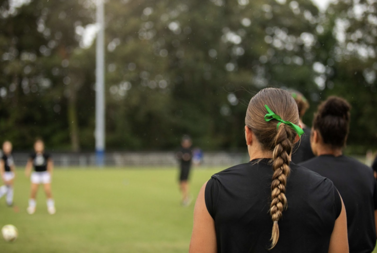 Estella Gajarsky Prado wearing a green ribbon at the women’s soccer mental health awareness game.