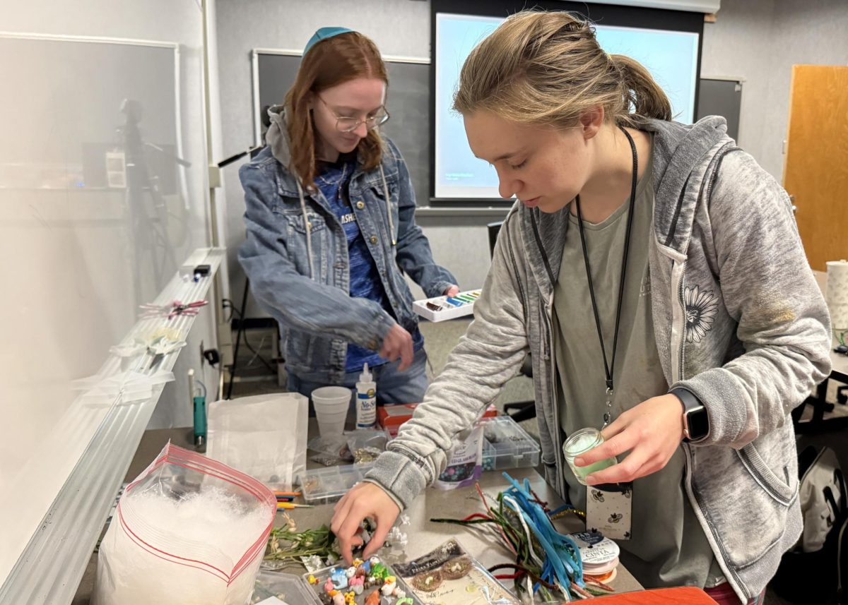 Cassidy Bricker and Catherine Latham gathering supplies to make trinkets in Karpen Hall.