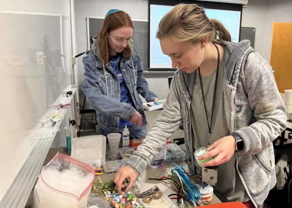 Cassidy Bricker and Catherine Latham gathering supplies to make trinkets in Karpen Hall.
