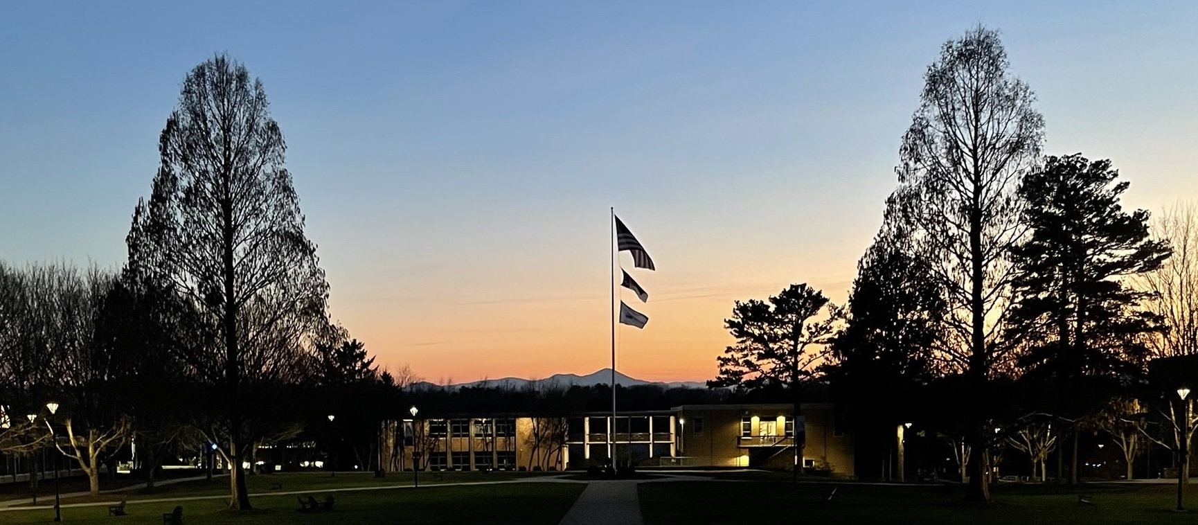 UNCA flagpole in quad during sunset.