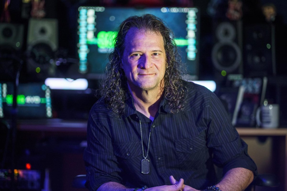 Dan Friedman, a longtime Asheville-area voice actor, sits in his home studio, where he records and coaches performers amid microphones and audio equipment.
